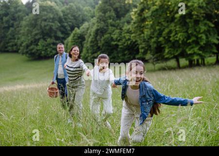 Familie auf einem interessanten Spaziergang im Wald, auf einer Wiese. Pilze, Kräuter, medizinische Pflanzen oder Blumen sammeln, auf der Suche nach Nahrungsmitteln. Familienökologisches Konzept Stockfoto