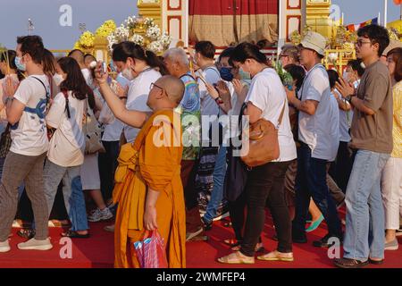 Während der Feierlichkeiten zum Makha Bucha (buddhistisches Festival) in Bangkok, Thailand, macht ein buddhistischer Mönch ein Selfie mit Laienanbetern im Hintergrund Stockfoto