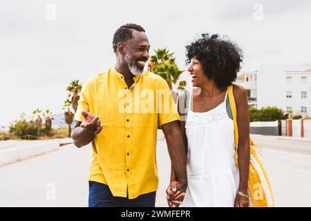 Wunderschönes reifes schwarzes Paar von Liebhabern, die sich am Meer treffen - verheiratetes afrikanisches Paar mittleren Alters, das sich im Freien verbündet und Spaß hat, Konzepte über rel Stockfoto