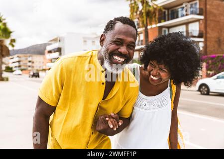 Wunderschönes reifes schwarzes Paar von Liebhabern, die sich am Meer treffen - verheiratetes afrikanisches Paar mittleren Alters, das sich im Freien verbündet und Spaß hat, Konzepte über rel Stockfoto