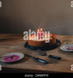 Geburtstagskuchen mit zündeten Kerzen in Form der Zahl achtzehn. Stockfoto