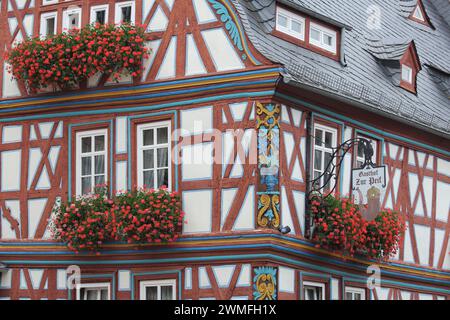 Fachwerkhaus und Gasthof zur Pfeif mit Ornamenten, Blumenschmuck und Nasenschild, Koenig-Adolf-Platz, Idstein, Taunus, Hessen, Deutschland Stockfoto