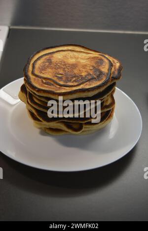 Ein herzhaftes Frühstück, köstlich zubereitete hausgemachte Speisen, viele große, flauschige Pfannkuchen sind auf einem großen weißen Teller angeordnet. Stockfoto