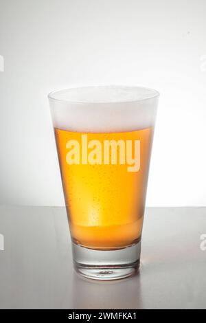 Eine vertikale eines Glases Bier auf einem Tisch Stockfoto