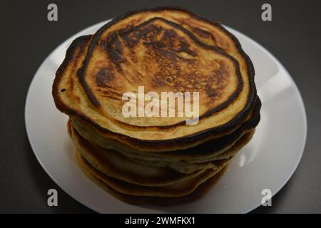 Ein herzhaftes Frühstück, köstlich zubereitete hausgemachte Speisen, viele große, flauschige Pfannkuchen sind auf einem großen weißen Teller angeordnet. Stockfoto