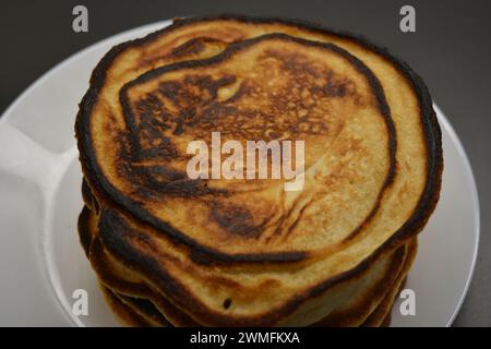 Ein herzhaftes Frühstück, köstlich zubereitete hausgemachte Speisen, viele große, flauschige Pfannkuchen sind auf einem großen weißen Teller angeordnet. Stockfoto