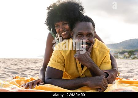 Wunderschönes reifes schwarzes Paar von Liebhabern, die sich am Meer treffen - verheiratetes afrikanisches Paar mittleren Alters, das sich im Freien verbündet und Spaß hat, Konzepte über rel Stockfoto
