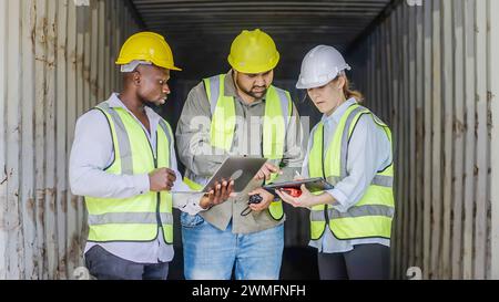 Eine vielfältige Gruppe von professionellen Hafenarbeitern, die Daten in einem Containerterminal überprüfen Stockfoto