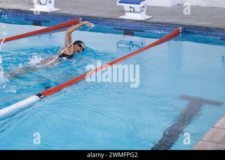 Die weibliche Athletin schwimmt in einem Hallenbad Stockfoto