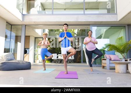 Junger asiatischer Mann führt Yoga-Session zu Hause, mit Kopierraum Stockfoto