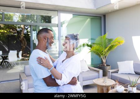 Ein hochrangiges birassisches Paar teilt sich zu Hause einen zärtlichen Moment Stockfoto