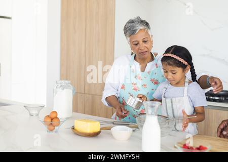 Birassische Großmutter und Enkelin backen gemeinsam in einer Küche mit Kopierraum Stockfoto