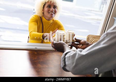 Eine junge birassische Frau genießt einen Kaffee mit einem Afroamerikaner, mit Kopierraum Stockfoto