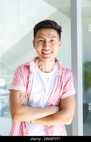 Junger asiatischer Mann steht zuversichtlich zu Hause, mit Kopierraum Stockfoto
