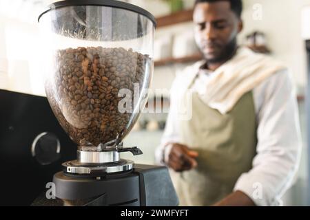 Der afroamerikanische Barista bereitet Kaffee in einem Café zu Stockfoto