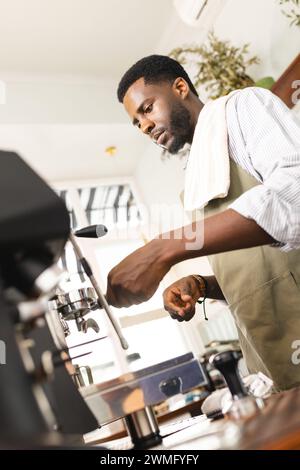 Der afroamerikanische Barista bereitet Kaffee in einem Café mit Platz für Kopien zu Stockfoto