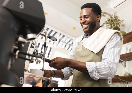 Der afroamerikanische Barista bereitet Kaffee in einem Café zu Stockfoto