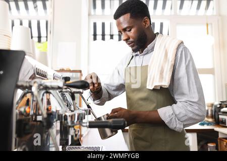 Der afroamerikanische Barista bereitet Kaffee in einem Café zu Stockfoto