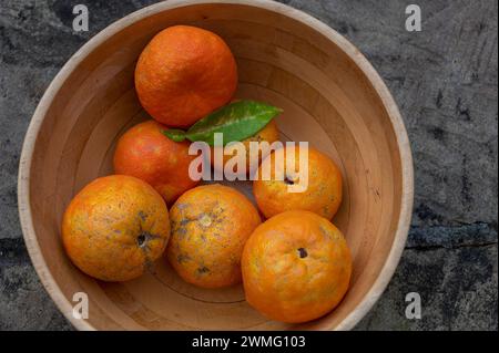 Eine Schüssel mit kleinen Bitterorangen oder sevillischen Orangen mit entkernten Häuten, die in den Straßen um Cordoba angebaut werden und so ein angenehmes Orangenaroma erzeugen Stockfoto