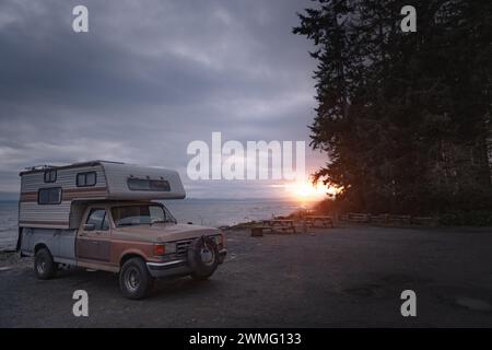 Vintage-Wohnmobil parkte vor dem Meer bei Sonnenuntergang Stockfoto