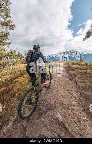 Eine Frau, die mit Bergen im Hintergrund fährt Stockfoto