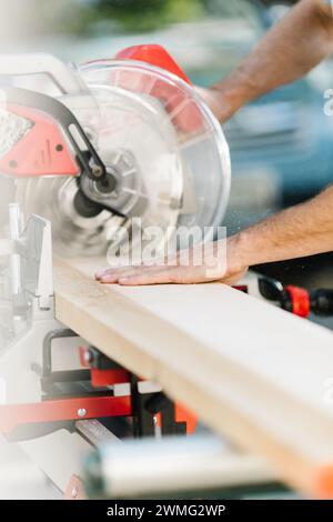 Zimmermann mit Gehrungssäge für Holzarbeiten. Stockfoto