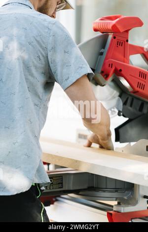 Zimmermann mit Gehrungssäge für präzise Schnitte. Stockfoto