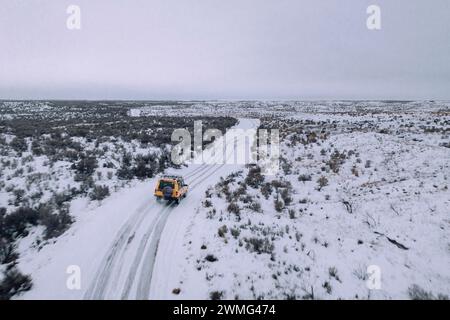 Ein Geländewagen fährt an einem bewölkten Tag durch den Schnee. Stockfoto