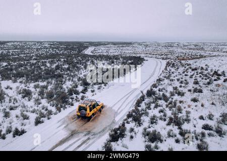 Ein Geländewagen fährt an einem bewölkten Tag durch den Schnee. Stockfoto