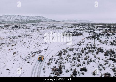 Ein Geländewagen fährt an einem bewölkten Tag durch den Schnee. Stockfoto