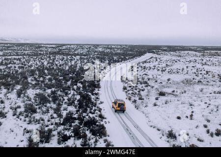 Ein Geländewagen fährt an einem bewölkten Tag durch den Schnee. Stockfoto