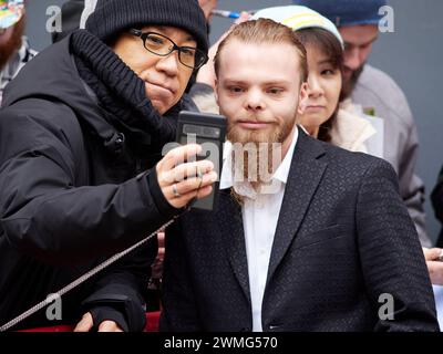 Berlin, Deutschland, 18. Februar 2024. 74. Berlinale, Schauspieler Julien Manier macht Selfies mit Fans bei Ankunft der Pressekonferenz. Credits: Walter Gilgen Stockfoto