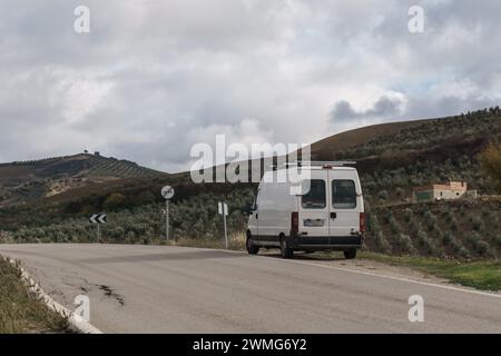 Camper auf der Straße in der rustikalen Landschaft Andalusiens von Olivenbäumen an den Hängen der Berge, Setenil de las Bodegas, Andalusien, Spanien Stockfoto