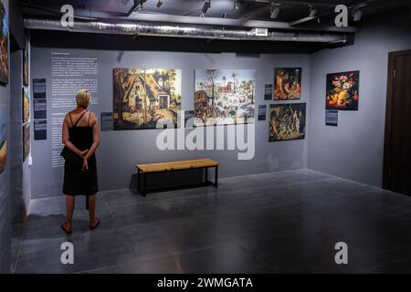 Leute in der Ausstellung in der Galerie für moderne Kunst, die die Gemälde sehen. Innenraum der modernen Kunstgalerie mit Gemälden an den Wänden Stockfoto