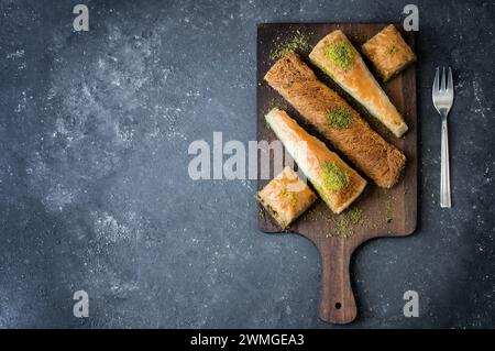 Traditionelles türkisches Dessertkonzept, Kadayif, Karottenscheibe, Vorspeisenbaklava mit Pistazien auf rustikalem Hintergrund Stockfoto