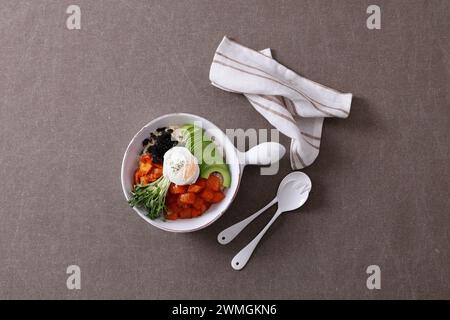 Koreanisches Essen. Lachs Poke Schüssel mit Avocado, Rucola und pochiertem Ei. Stockfoto