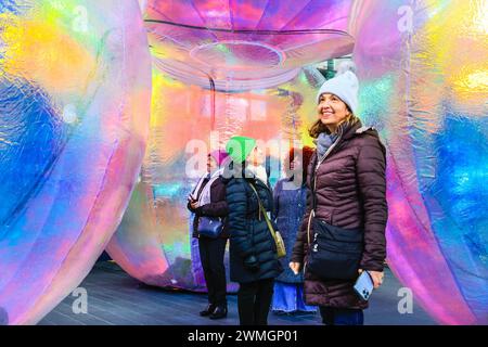 London, Großbritannien. Februar 2024. Besucher mit der Installation. Riesige, regenbogenfarbene Elysische Bögen werden am Fuße des Leadenhall Building in der City of London enthüllt. Die kostenlose, immersive Licht- und Klanginstallation, die von Atelier Sisu geschaffen wurde, wurde vom Eastern City Business Improvement District in Auftrag gegeben und FESTIVAL.ORG produziert, um das geistige, physische und ökologische Wohlbefinden der Arbeiter in der Stadt und in ganz London zu unterstützen, als Teil der einjährigen WIEDERAUFLADUNGSKAMPAGNE 2024 des BID. Quelle: Imageplotter/Alamy Live News Stockfoto