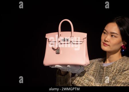 London, England, Großbritannien. Februar 2024. Ein Mitarbeiter mit einer HermÃ¨s: Rose Sakura Swift Leather Birkin 25, 2023, (Est. â 18.000 £ - Â 000 £) bei einer Vorschau auf Bonhams kommende Designer Handtaschen und Fashion Sale (Credit Image: © Tayfun Salci/ZUMA Press Wire) NUR ZUR REDAKTIONELLEN VERWENDUNG! Nicht für kommerzielle ZWECKE! Quelle: ZUMA Press, Inc./Alamy Live News Stockfoto