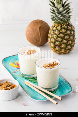 Ananas-Kokos-Protein-Smoothies mit Granola und Kokosflocken. Stockfoto