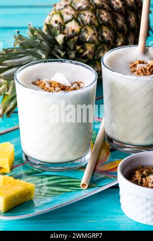 Erfrischende Gläser Ananas-Smoothies garniert mit Müsli. Stockfoto