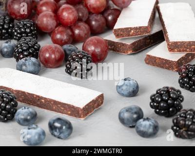 Dunkle Fruchtscheiben, dekoriert mit Heidelbeeren, Brombeeren und roten Trauben Stockfoto