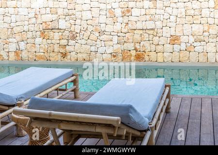 Leere Liegestühle neben dem privaten Pool auf der Terrasse eines Luxushotels. Tourismuskonzept. Stockfoto