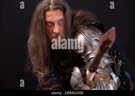 Porträt eines charismatischen Mannes, gekleidet als mittelalterlicher Ritter mit einem Speer während einer historischen Nachstellung. Stockfoto