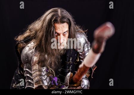 Performance für Touristen. Porträt eines charismatischen Mannes, gekleidet als mittelalterlicher Ritter mit einem Speer während einer historischen Nachstellung. Stockfoto