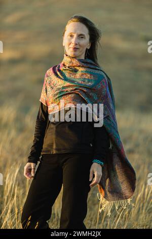 Porträt einer erwachsenen kaukasischen Frau mit einem zurückhaltenden Lächeln im Sonnenuntergang. Vertikale Zusammensetzung. Stockfoto