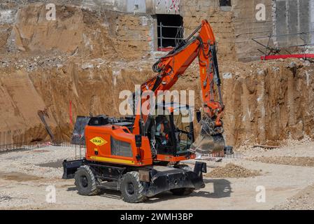 Nancy, Frankreich – orangefarbener Radbagger CAT M317F für Erdarbeiten auf einer Baustelle. Stockfoto