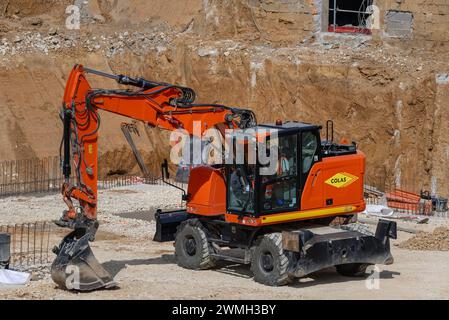 Nancy, Frankreich – orangefarbener Radbagger CAT M317F für Erdarbeiten auf einer Baustelle. Stockfoto