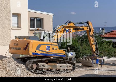 Vandœuvre-lès-Nancy, Frankreich - Gelber Raupenbagger Liebherr R 918 auf Baustelle für Arbeiten am Trinkwassernetz. Stockfoto