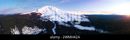 Dämmerung beleuchtet Mount St. Helens, ein landschaftlicher und aktiver Stratovulkan, der aus der üppigen, bewaldeten Landschaft in Washington entspringt. Stockfoto