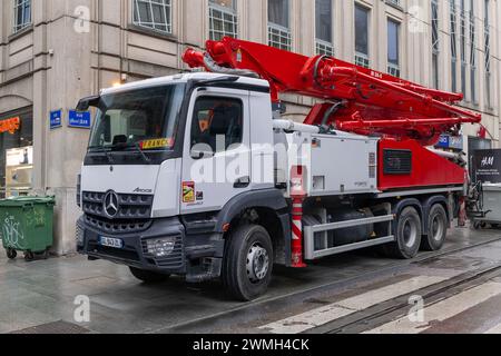 Nancy, Frankreich – Fokus auf eine weiß-rote Betonpumpe Putzmeister M38-5 am Mercedes-Benz Arocs 2640, die auf einer Straße geparkt ist. Stockfoto